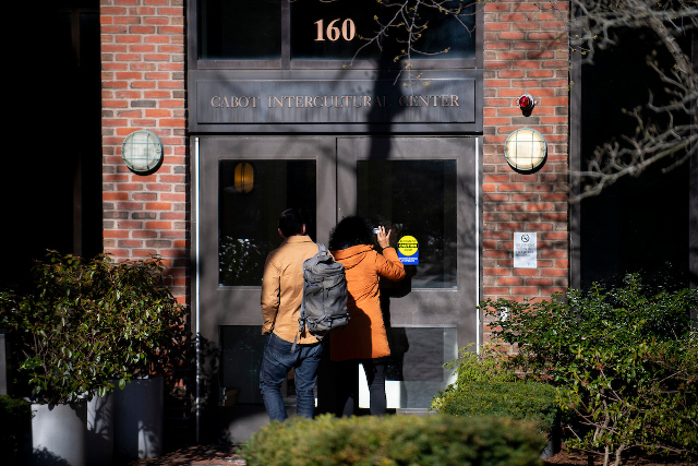 3月16日，校园大楼关闭后，弗莱彻社区成员通过卡伯特国际中心的门窥视。照片：Alonso Nichols