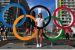 高丽卡·辛格在东京奥运五环前。塔夫茨大学一年级学生高丽卡·辛格（Gaurika Singh）是尼泊尔游泳队的一员，并在开幕式上举着尼泊尔国旗。
